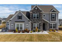 Charming two-story home with a stone facade and well-manicured lawn at 7133 Sumters Camp Trl, Fort Mill, SC 29707