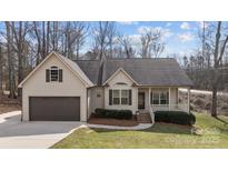 Charming single-Gathering home features a covered front porch, attached two car garage, and manicured lawn at 910 Pine Knoll Rd # 13, Fort Mill, SC 29715