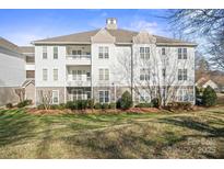 Well-maintained condo with multiple balconies, manicured landscaping, and charming architectural details, perfect for comfortable living at 10125 Westmoreland Rd, Cornelius, NC 28031
