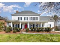 Charming home with a full front porch, white siding, dark shutters, and a red front door at 1263 Crooked Stick Dr, Rock Hill, SC 29730