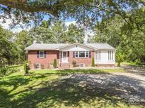 Charming brick home with a spacious front yard and mature trees providing ample shade at 1755 Simplicity Rd, Concord, NC 28025