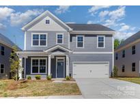 Charming two-story home featuring a covered entryway and attached two-car garage at 1803 Country Club Rd, Lincolnton, NC 28092