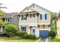 Charming two-story home with a light yellow exterior, blue shutters, and an attached garage at 1905 Summey Ave, Charlotte, NC 28205