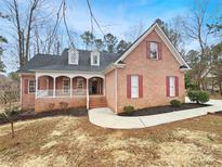 Charming brick home featuring a columned front porch, dormer windows, and well-maintained landscaping at 2068 Brandt Rd, York, SC 29745
