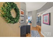 Condo entryway featuring stylish decor, including a wreath, storage, and framed art at 210 N Church St # 1413, Charlotte, NC 28202