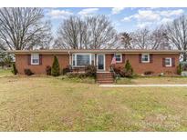 Charming brick ranch featuring manicured lawn and a welcoming front porch at 2205 Centergrove Rd, Kannapolis, NC 28083