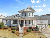 Charming two-story home with a welcoming front porch, American flag, and well-manicured lawn at 3013 Arsdale Rd, Waxhaw, NC 28173