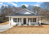 Charming home showcasing its inviting front porch, new landscaping, and well-manicured lawn at 407 S Spargo St, Dallas, NC 28034