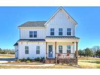 Charming white two-story home featuring a welcoming front porch and neatly landscaped yard at 623 Plowshare Way, Clover, SC 29710