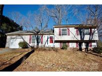 Charming two-story home featuring red shutters and a bright red front door, complemented by a well-maintained lawn at 6811 Rollingridge Dr, Charlotte, NC 28211