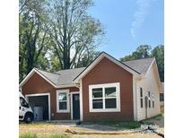 Charming single-Gathering home with a modern two-tone exterior and attached garage, nestled among lush trees at 822 3Rd Street Sw Pl, Hickory, NC 28602