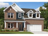 Charming two-story brick home with a covered front porch, attached two-car garage, and beautifully landscaped front yard at 11105 Lochmere Rd, Charlotte, NC 28278