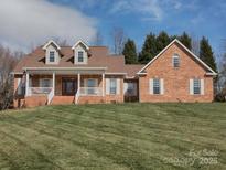 Charming brick home with a well-manicured lawn, inviting front porch, and classic architectural details at 144 Grandview Dr, Statesville, NC 28677