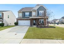 Charming two-story home features a landscaped front yard and a welcoming porch with stone accents at 14815 Superior St, Charlotte, NC 28273
