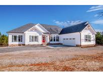 Beautiful one-story home with white siding, dark shutters and a red front door with attached two-car garage at 150 Belk Estate Dr, Mooresville, NC 28115
