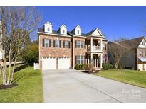 Charming brick home featuring a manicured lawn, dormers, and two-car garage, offering classic curb appeal at 1590 Abercorn Nw St, Concord, NC 28027