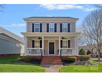 Charming two-story home featuring a welcoming front porch and well-maintained landscaping at 16504 Knox Run Rd, Huntersville, NC 28078