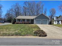Charming single-story home featuring a two-car garage and a welcoming front porch, complemented by a landscaped lawn at 2630 Sloan Dr, Charlotte, NC 28208