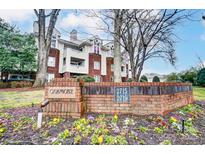Attractive brick condo building featuring beautiful landscaping and manicured grounds at Oakmore at 2719 Selwyn Ave # 6, Charlotte, NC 28209