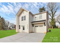 Charming two-story home with a garage and concrete driveway on a grassy lawn under a bright blue sky at 2765 Bradford St, Gastonia, NC 28054