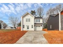 Modern two-story home featuring white siding, black roof and trim, with a concrete driveway at 2765 Bradford St, Gastonia, NC 28054
