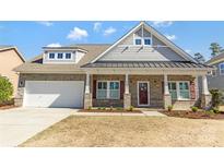 Charming brick home featuring a covered front porch, two-car garage and beautiful architectural details at 2934 Hiddenbrook Way, Fort Mill, SC 29707