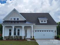 Charming single-Gathering home featuring a two-car garage, inviting porch, and manicured lawn at 305 Basil Dr, Indian Trail, NC 28079