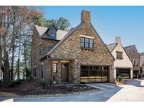Charming stone home with a two-car garage and cozy covered porch, perfect for lakeside living at 326 Ambleside Village Ln, Davidson, NC 28036