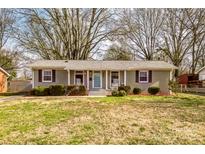 Charming single-story home featuring a well-maintained lawn and a welcoming front porch with rocking chairs at 4227 Winedale Ln, Charlotte, NC 28205