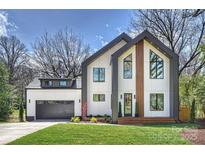 Modern home showcasing architectural design, a well-manicured lawn, and a gray garage door at 4808 Doris Ave, Charlotte, NC 28205