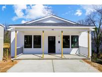 Charming home featuring a covered porch, black-framed windows, and freshly painted white siding at 66 Reed Ne St, Concord, NC 28025