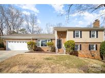 Charming home with a well-maintained lawn, brick facade, and a spacious two-car garage at 7300 Falkirk Pl, Charlotte, NC 28270