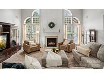 Bright living room features high ceilings, a fireplace, and a cozy seating area with natural light at 809 Circle Trace Rd, Monroe, NC 28110