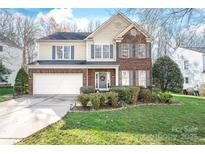 Charming two-story home featuring a blend of brick and siding, complemented by a well-manicured lawn and an attached two-car garage at 8823 Deerland Ct, Huntersville, NC 28078