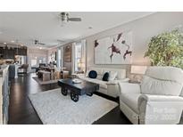 Spacious living area flowing into the dining space, furnished with modern decor and bright accents at 919 Pennington Dr, Lancaster, SC 29720