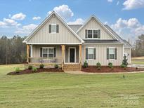 Charming new construction home featuring a covered porch and a beautifully landscaped front yard at 1324 Sage Pine Cir, Clover, SC 29710
