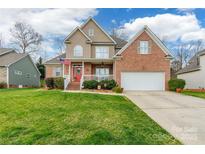 Charming two-story home with a red brick and siding exterior, front porch, and well-manicured lawn at 1655 Essex Hall Dr, Rock Hill, SC 29730
