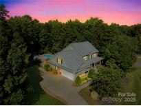 Charming two-story home featuring mature trees, lush landscaping, in-ground pool, and attached two-car garage at 174 Logan Crossing Dr, Davidson, NC 28036