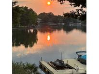 Beautiful lake view with a private dock, jet ski lift, and a covered boat slip at sunset at 17701 Springwinds Dr, Cornelius, NC 28031