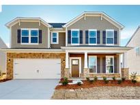 Charming two-story home featuring a stone facade, covered porch, and a two-car garage at 1812 Augustine St, Monroe, NC 28112