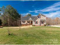 Charming two-story home featuring a landscaped yard, complemented by red shutters against the tan siding at 2050 Sunswept Ln, York, SC 29745