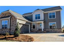 Beautiful two-story home featuring stone accents, gray siding, and well-manicured landscaping at 2084 Fordhill St, Rock Hill, SC 29732