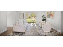 Cozy living room with white furniture, a glass coffee table, and sliding glass doors to the backyard at 2509 Lanecrest Dr, Charlotte, NC 28215