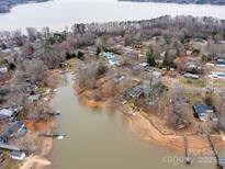 An aerial view of lakefront homes with docks, surrounded by trees in a quiet community on a cloudy day at 265 Sailboat Dr, Salisbury, NC 28146