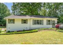 Charming single-story home featuring manicured front lawn and well-maintained landscaping and inviting entrance at 3231 Eastwood Dr, Charlotte, NC 28205