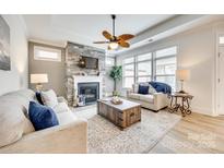 Bright living room with a stone fireplace, large windows, and stylish décor at 333 Lifestyle Ct, Cramerton, NC 28056