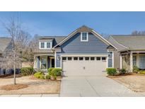 Charming home with a two-car garage, blue siding, manicured landscaping and a clear blue sky at 4521 Middlebury Ln, Fort Mill, SC 29715