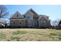 Charming brick home featuring a symmetrical design, arched windows, and well-manicured lawn under a clear blue sky at 4531 Landmark Dr, Rock Hill, SC 29732