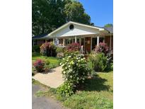 Charming single-story home with lush landscaping, colorful flower bushes, and inviting front porch at 4805 Nesbit Rd, Monroe, NC 28112
