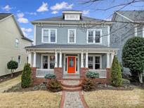 Charming two-story home featuring a welcoming front porch with an orange door and manicured landscaping at 786 Stratford Run Dr, Fort Mill, SC 29708